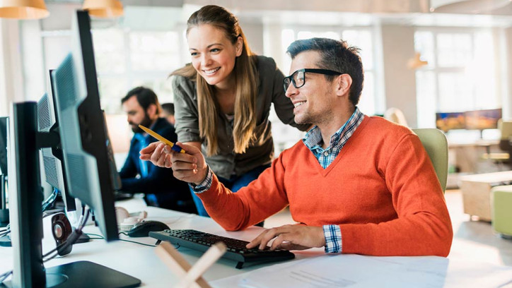 Woman and man using computer in office